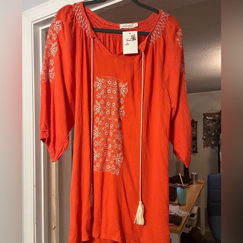Nice tunic in a dark coral with a cream colored design.